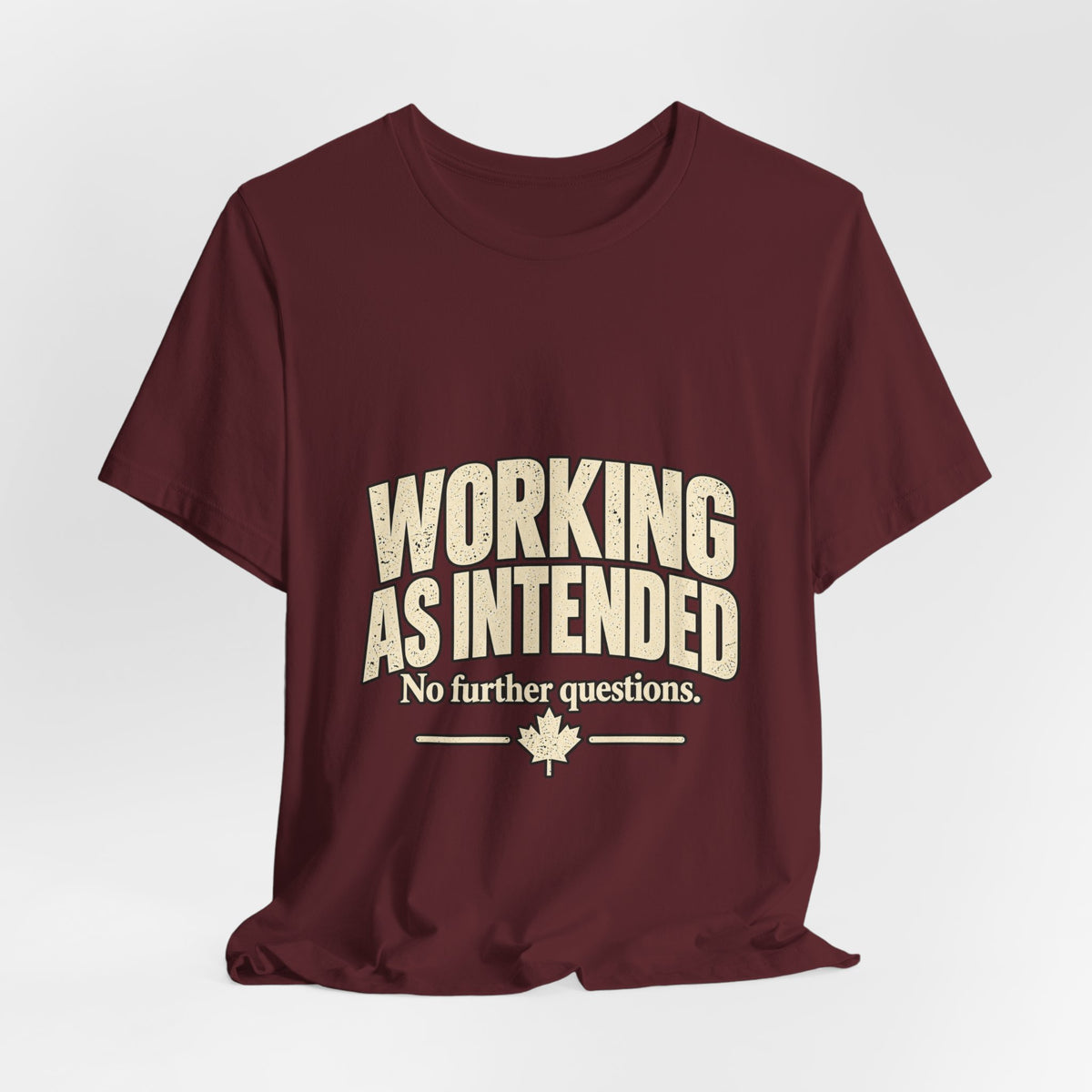 Draped maroon Working As Intended T-shirt showing the full cream design and maple leaf.