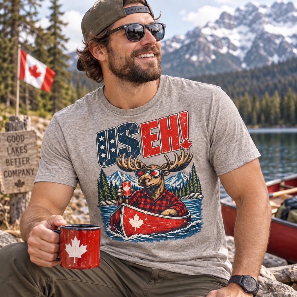 US EH! grey shirt lifestyle mockup beside a Canadian mountain lake
